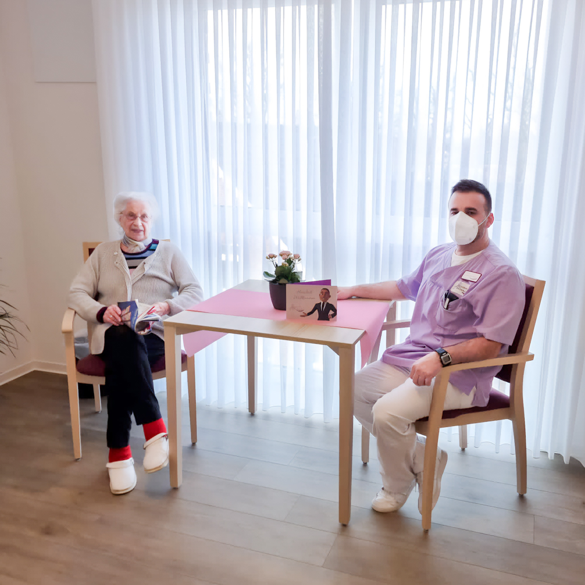 Web-Residenz-Heidebluete-Pfleger-mit-Patientin-Tisch